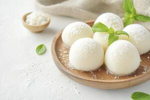 Mochi Ice Cream Balls Served with Coconut and Mint Leaves Still Life photo