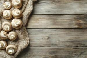 Button Mushrooms on Burlap Sack with Rustic Wooden Table Background photo