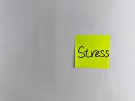 The word Stress is written on sticky note with marker photo