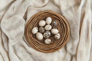 Speckled Bird Eggs in Woven Nest Resting on Soft Linen Fabric photo