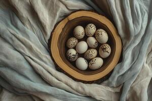 Speckled Eggs in Wooden Bowl on Flowing Fabric Background photo