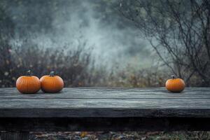 Pumpkins on a Rustic Table in Spooky Autumn Foggy Landscape photo