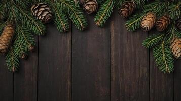 Fir Branch and Pine Cone Border on Dark Wood Background photo
