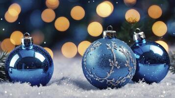 Festive Blue Christmas Ornaments Displayed on Soft White Snow with Bokeh Lights photo