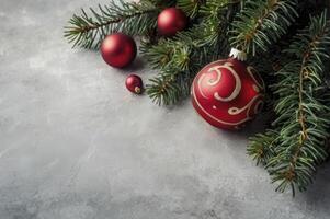 Red Christmas Ornaments with Fir Branches on Gray Background Holiday Decor photo