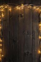 Wooden Plank Background with Glowing String Lights Border for Festive Occasions photo