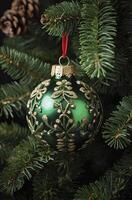 Hanging Green Christmas Ornament on Pine Tree Branch Festive Decoration photo