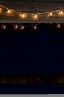 Glowing String Lights on Rustic Wood Wall Background Creates Warm Ambiance photo