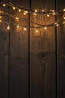 Festive Glowing String Lights Hung on a Rustic Dark Wood Background photo