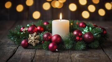 Christmas Candle Burning on Wreath with Red Ornaments and Bokeh Lights photo