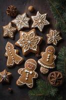 Festive Gingerbread Cookies and Spruce Sprigs on Rustic Wooden Background photo