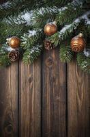 Christmas Tree Branch with Ornaments and Snow on Wooden Surface photo
