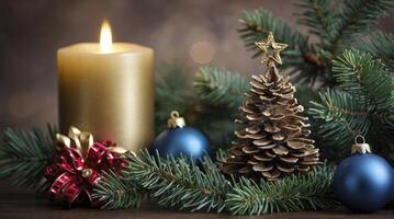 Burning Candle with Christmas Decorations and Pine Cone Tree Ornament photo