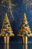 Decorative Christmas Trees with Gold Ornaments on a Sparkling Blue Background photo