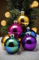 Colorful Christmas Ornaments Display on Snow with Pine Tree Branches photo
