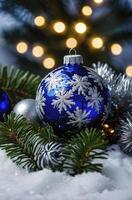 Blue Christmas Ornament with Snowflakes on Green Branches and Bokeh Lights photo