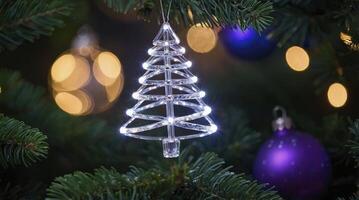 Illuminated Christmas Tree Ornament Hanging on Green Fir Branch photo