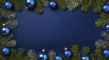 Christmas Ornaments and Evergreen Branches Bordering a Blue Background photo
