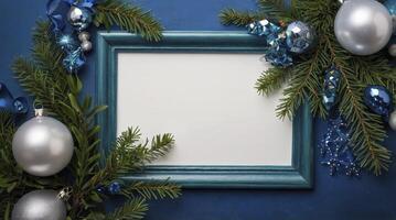 Christmas Decoration with Frame, Ornaments and Fir Branches on Blue Background photo