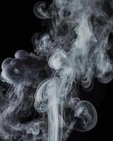 Rising Smoke Creates Abstract Swirls Against a Dark Background photo