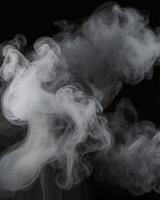 Wispy White Smoke or Vapor Flowing Against a Black Background photo