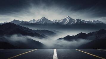 Driving Towards Snowy Mountain Peaks Through Mist on Empty Asphalt Road photo