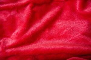 Red shimmering plush fabric colour, close-up texture. photo