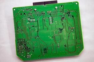 Background and texture of a printed circuit board with microchips and chips from a car safety module photo