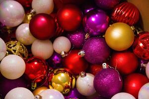 Close-up of colourful Christmas tree ornaments in red, gold, and pink shades for decorating a Christmas tree. photo