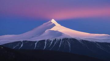 Snowy Mountain Peak at Dawn with Beautiful Pink and Blue Sky photo