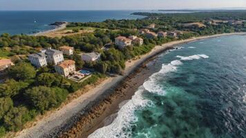 Aerial View of Coastal Homes Along Shoreline with Waves Crashing photo