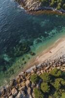 Aerial View of Coastline with Turquoise Water, Sandy Beach and Rocks photo