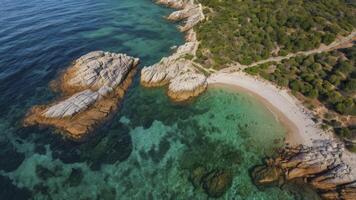 Aerial View of Secluded Beach Cove with Turquoise Water and Rocky Outcrops photo