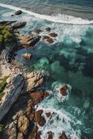 Aerial View of Ocean Waves Crashing on Rocky Shoreline with Turquoise Water photo