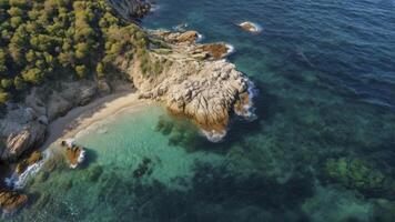 Aerial View of Rocky Coastline with Sandy Beach and Turquoise Water photo