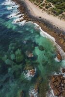 Aerial View of Turquoise Ocean Water Meets Sandy Beach with Rocks photo