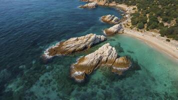 Aerial View of Rocky Coastline with Turquoise Water and Sandy Beach photo