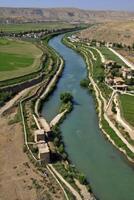Aerial View of River Winding Through Green Valley and Rural Landscape photo