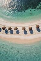 Aerial View of Tropical Beach with Umbrellas and Turquoise Ocean Water photo