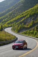 Driving a Red Car on a Scenic Mountain Road Trip Adventure photo
