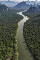 River Winding Through Green Forest and Mountain Landscape From Above photo