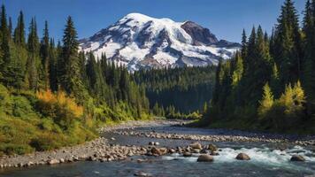 River Flowing Through Forest with Snow-capped Mountain View on Clear Day photo