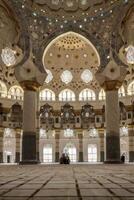 Exploring Interior of Grand Mosque with Ornate Architecture and Tile Floor photo