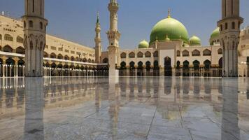 Mosque Reflecting on Marble Floor with Green Domes and Tall Minarets photo