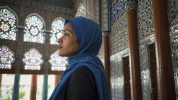 Woman in Hijab Looking Upward in Ornate Interior with Stained Glass photo