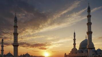 Mosque Silhouette at Sunset with Minarets and Golden Sky Glow photo