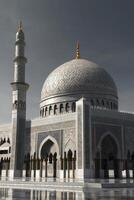 Majestic Mosque Architecture Featuring Dome and Minaret Under Cloudy Sky photo