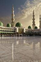 Majestic Mosque with Green Domes and Minarets at Dusk in Medina Saudi Arabia photo