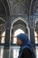 Woman Wearing Hijab Inside Historic Building with Intricate Islamic Architecture photo