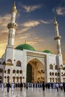 Pilgrims Gather at Quba Mosque Medina with Green Dome and Minarets photo